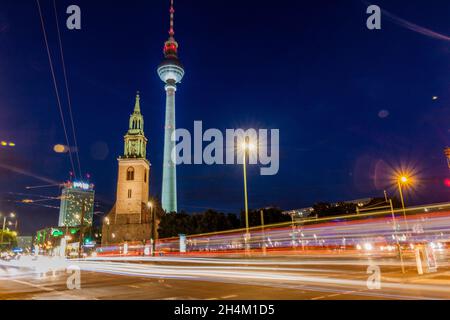 BERLIN, ALLEMAGNE - 9 AOÛT 2017 : vue en soirée de l'église Sainte Marie de Marienkirche et de la tour de télévision Fernsehturm avec une lumière de circulation. Banque D'Images