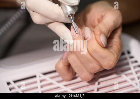 Femme qui fait manucure pour elle-même avec le foret à ongles.Photo de haute qualité Banque D'Images