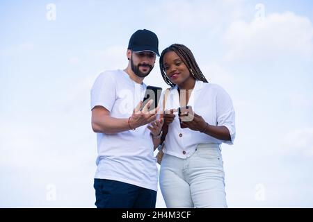 Deux amis rient avec Funny Media sur Mobile Banque D'Images
