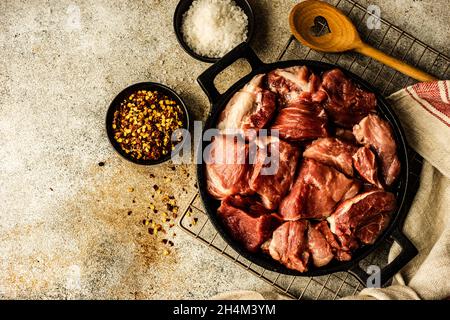 Viande de porc crue et épices sur fond de béton comme concept de cuisine Banque D'Images