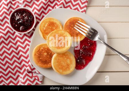 Crêpes au fromage cottage avec confiture de fraises sur fond blanc, vue de dessus Banque D'Images