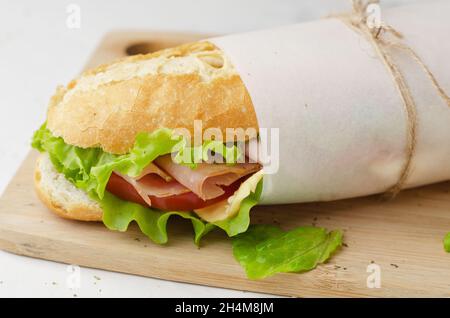 Sandwich sous-marin frais avec jambon, fromage, bacon, tomates et salade Banque D'Images