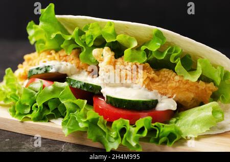 Pita avec poulet et légumes sur fond sombre Banque D'Images