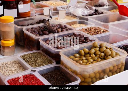 Olives marinées et casse-croûte de noix à l'intérieur de récipients en plastique vendus sur le marché Banque D'Images