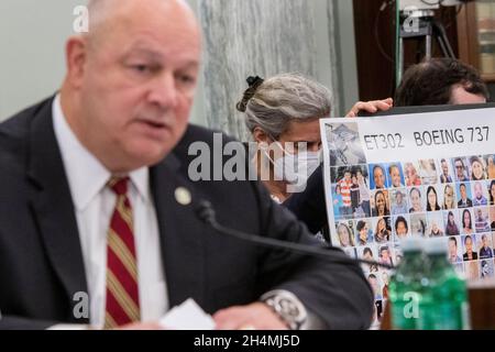 Nadia Milleron, à droite, la mère de Samya Rose Stumo tient un panneau avec des photos des victimes du vol 302 d'Ethiopian Airlines, tandis que Steve Dickson, administrateur, Administration fédérale de l'aviation, à gauche,Comparaît devant une audience du Comité sénatorial sur le commerce, les sciences et les transports pour examiner la mise en œuvre de la réforme de la sécurité aérienne, dans l'édifice du bureau du Sénat Russell à Washington, DC, le mercredi 3 novembre 2021.Samya Rose Stumo était à bord du vol 302 de la compagnie aérienne éthiopienne le 10 mars 2019, lorsque le Boeing 737 MAX 8 s'est écrasé près de la ville de Bishoftu six minutes après le décollage, killi Banque D'Images