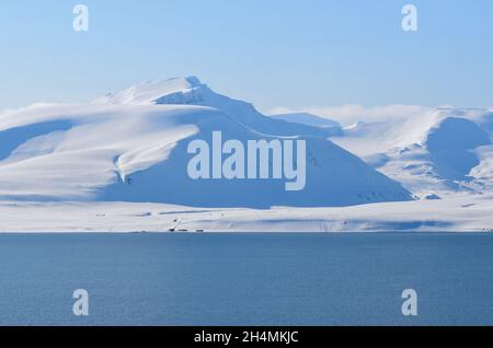 La beauté magique de Svalbard.Neige exceptionnellement bleue contre le ciel dégagé.Fjords et montagnes avec neige éternelle sur l'île de Svalbard Banque D'Images