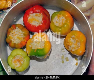 Gros plan des étapes de mise farcie de riz et de carottes poivrons dans une casserole en aluminium. Banque D'Images