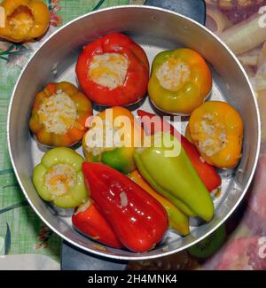 Gros plan des étapes de mise farcie de riz et de carottes poivrons dans une casserole en aluminium. Banque D'Images