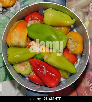 Gros plan des étapes de mise farcie de riz et de carottes poivrons dans une casserole en aluminium. Banque D'Images