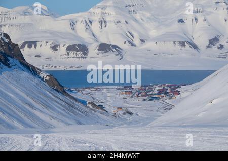 La beauté magique de Svalbard. Neige exceptionnellement bleue contre le ciel dégagé. Village minier près du fjord sur l'île de Svalbard Banque D'Images