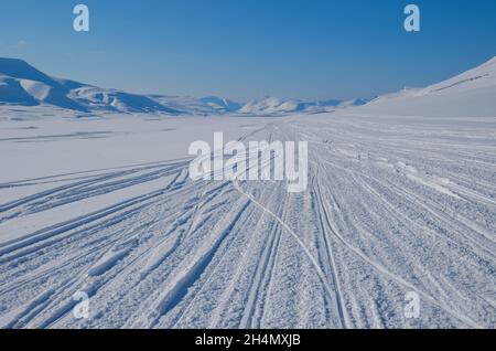 La beauté magique de Svalbard.Neige exceptionnellement bleue contre le ciel dégagé.Route enneigée dans les montagnes.Concept de minimalisme. Banque D'Images