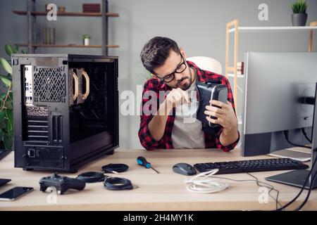Portrait d'un homme intelligent et attrayant qui fixe les terminaux vr cyberespace garantie au poste de travail de bureau en intérieur Banque D'Images