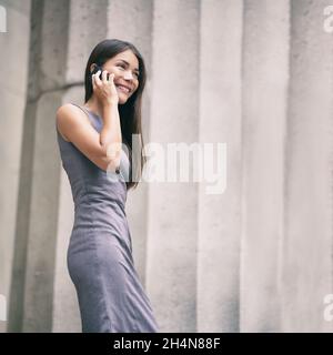 Appelez une femme d'affaires à l'aide d'un téléphone intelligent parlant.Femme d'affaires asiatique appelant sur un appareil mobile se promenant dans l'immeuble de la ville. Banque D'Images