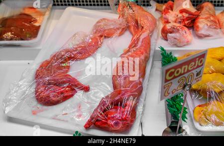 Lapin entier habillé avec une étiquette spécifiant la viande comme lapin à vendre dans un boucher local dans la vieille ville ou Casco Viejo à Pampelune Espagne Banque D'Images
