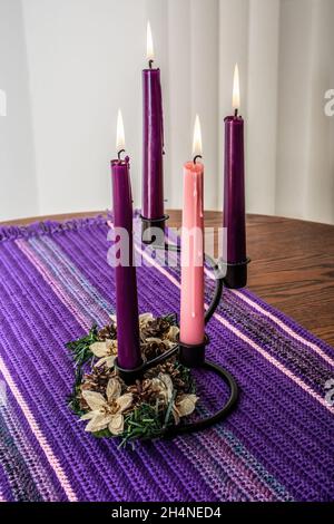 Des bougies sont placées sur une couronne de fleurs sur un chemin de table en forme de crochetée maison. Banque D'Images