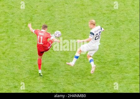 Saint-Pétersbourg, Russie – 16 juin 2021.L'équipe nationale russe de football milieu de terrain Roman Zobnin contre le buteur finlandais Joel Pohjanpalo pendant L'EURO 20 Banque D'Images