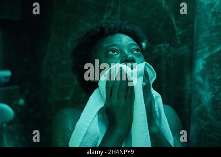 Une jeune femme africaine essuyant son visage avec une serviette après la douche Banque D'Images