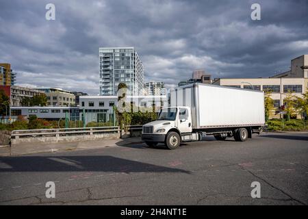 Compact industriel professionnel blanc puissant de classe moyenne engin de jour semi-tracteur de camion avec remorque à caisse longue fonctionnant pour la livraison sur le cit urbain Banque D'Images