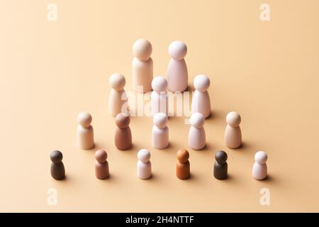 Des figurines simples ci-dessus de famille multiraciale et multigénérationnelle disposées en forme de pyramide sur fond beige Banque D'Images