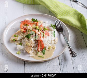 Repas sain avec filet de poisson poêlé servi avec des légumes, riz basmati dans une délicieuse sauce au lait de coco sur une assiette Banque D'Images