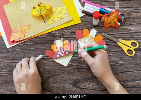 Étape d'instruction 12.L'artisanat de Thanksgiving marque le papier de dinde sur une table en bois.Projet d'art pour enfants, fait à la main, artisanat pour enfants. Banque D'Images