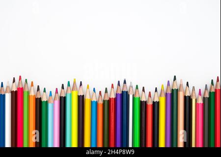 Retour à l'école ou concept de créativité.Cadre ondulé composé de crayons de couleur sur fond blanc. Banque D'Images