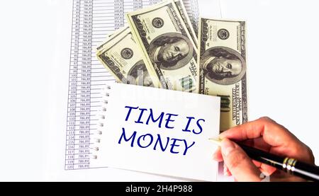 Le temps, c'est de l'argent, le concept financier sur les documents et les dollars Banque D'Images