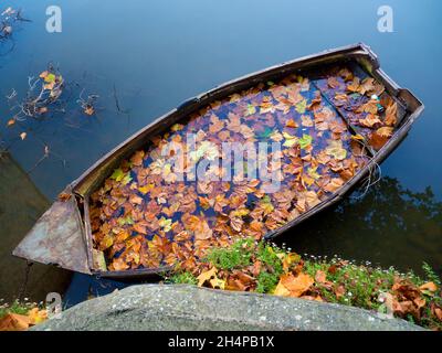 Une vue surréaliste - un bateau à rames en contrebas rempli de feuilles d'automne mortes ; vu par St Helens Wharf, un endroit de beauté réputé sur la Tamise à Abingdon, Banque D'Images