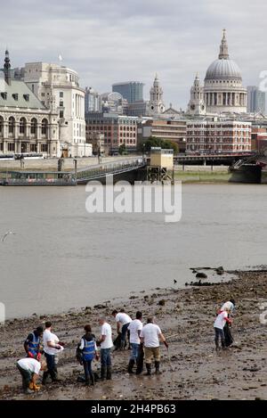 Une scène de bienvenue - des bénévoles ramassant des déchets des rives de la Tamise à marée basse près de la cathédrale Saint-Paul.La Tamise a été avec succès Banque D'Images