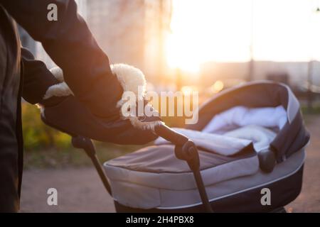 Mère se promenant avec le nouveau-né en chariot. Gros plan Banque D'Images