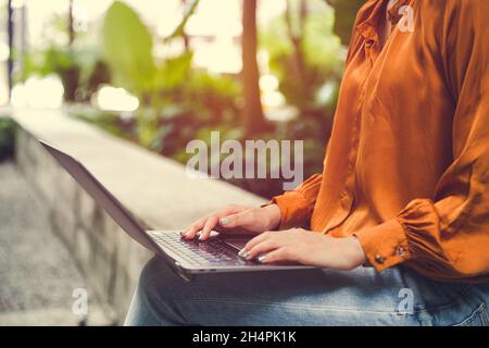Cropped shot of a woman at cafe travaillant sur son ordinateur portable. Close-up young businesswoman working on laptop at desk générique. Banque D'Images