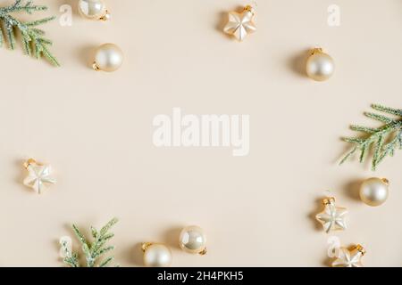 Élégante composition de Noël.Flat Lay boules dorées, étoiles et branches de sapin sur fond beige.Style hygge, confortable et nordique.Flat lay, vue de dessus. Banque D'Images