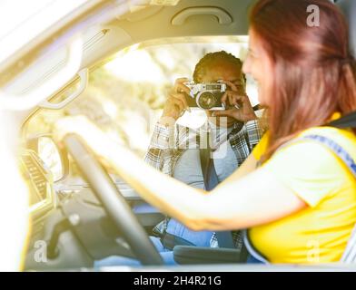 Femme noire prenant en photo un ami en voiture Banque D'Images