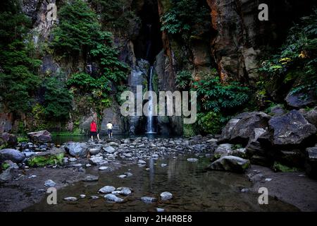 Mère et fils regardant la cascade Cascata do Salto do Cabrito sur l'île de Sao Miguel, Açores, Portugal Banque D'Images