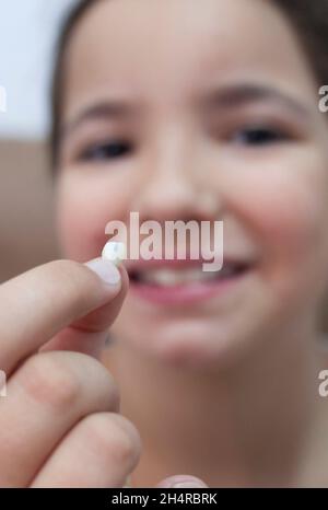 fille de 9 ans montrant sa première dent canine tombée.Mise au point sélective Banque D'Images