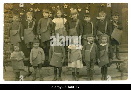 Original charmant et clair, carte postale de l'époque édouardienne d'un groupe de jeunes enfants d'école portant leurs sacoches lors d'un défilé du jour de mai, Norwich. Beaucoup de petits caractères. La carte postale est datée de 1 mai 1906. Norwich, Norfolk, Angleterre, Royaume-Uni Banque D'Images