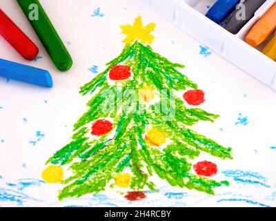 Arbre de Noël décoré dans la neige.Un dessin à la main peinture pastel à l'huile avec quelques pastels à l'huile près d'elle. Banque D'Images