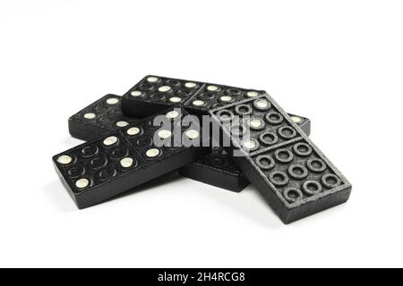 Pile de dominos noirs isolés sur fond blanc. Jeu pour famille et amis Banque D'Images