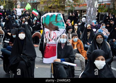 Téhéran, Iran.04e novembre 2021.Un manifestant tient une poignée ornée du drapeau iranien lors d'un rassemblement devant l'ancienne ambassade des États-Unis commémorant l'anniversaire de sa saisie de 1979 à Téhéran, en Iran, le jeudi 4 novembre 2021.La prise de pouvoir de l'ambassade a déclenché une crise d'otages de 444 jours et une rupture des relations diplomatiques qui se poursuit jusqu'à ce jour.(Photo de Sobhan Farajvan/Pacific Press/Sipa USA) crédit: SIPA USA/Alay Live News Banque D'Images