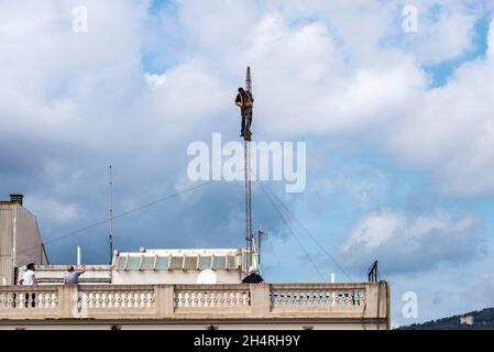 Barcelone, Espagne - 1er octobre 2021 : ouvrier de la construction démontant une antenne sur le toit d'un immeuble résidentiel à Barcelone, Espagne Banque D'Images