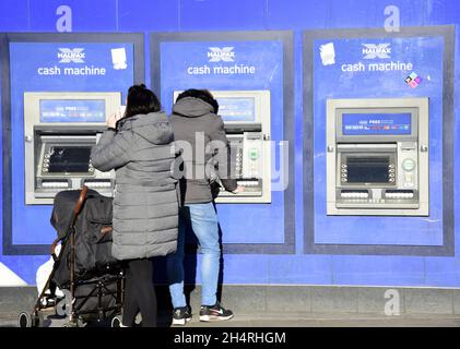 Une personne utilise un guichet automatique ou un guichet automatique de Halifax à Piccadilly, dans le centre de Manchester, au Royaume-Uni Banque D'Images
