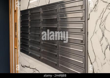 Boîtes aux lettres sur le mur dans l'entrée d'un immeuble à appartements. Banque D'Images