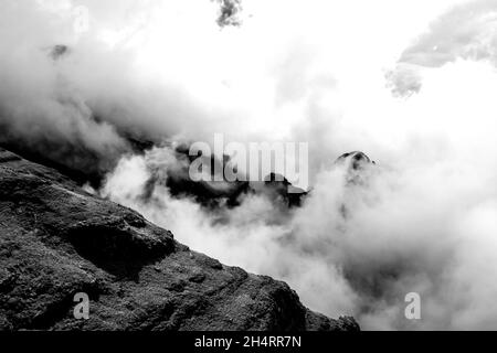 Les sommets déchiquetés des montagnes du Drakensberg, en Afrique du Sud, entourés de nuages en noir et blanc.Ces falaises abruptes emblématiques et ces pics dentelés forme Banque D'Images