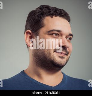 jeune homme positif portrait en chandail bleu à l'arrière-plan du studio Banque D'Images