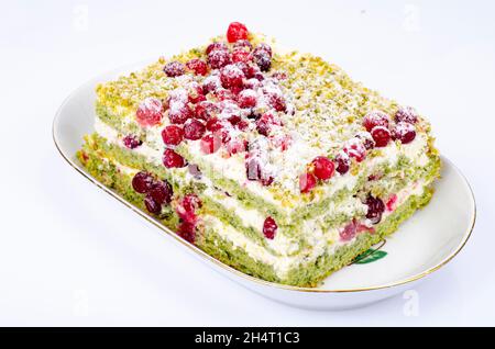 Morceau de gâteau doux avec crème et canneberges rouges.Studio photo Banque D'Images