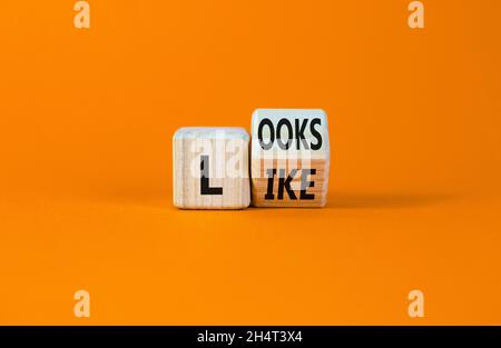 Ressemble à un symbole.A transformé un cube en bois avec les mots « ressemble à ».Magnifique arrière-plan orange.Affaires, citations populaires et ressemble à un concept.Copier sp Banque D'Images