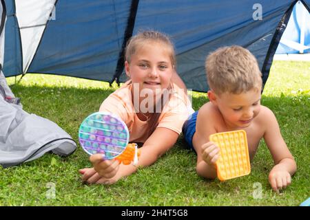 Pop IT jouet ou jeu de société avec les enfants jouant à l'extérieur, développement des compétences de moteur, appuyant les bulles avec les doigts, antistress pop jouet tendance.Concent Banque D'Images