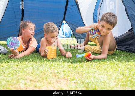 Pop IT jouet ou jeu de société avec les enfants jouant à l'extérieur, développement des compétences de moteur, appuyant les bulles avec les doigts, antistress pop jouet tendance.Concent Banque D'Images