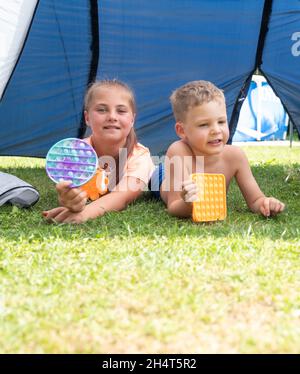 Pop IT jouet ou jeu de société avec les enfants jouant à l'extérieur, développement des compétences de moteur, appuyant les bulles avec les doigts, antistress pop jouet tendance.Concent Banque D'Images