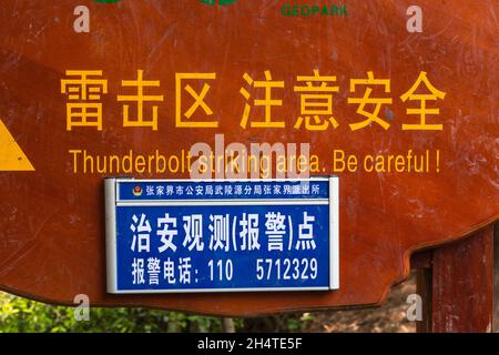 Un panneau d'avertissement sur un sommet de crête dans la région de Huangghi Zhai du parc forestier national de Zhangjiajie, Chine. Banque D'Images